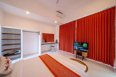 a bedroom with a large red curtain and a television at Villa Boha Seminyak in Seminyak