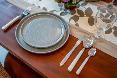 a table with a plate and cutlery on a table at Villa Boha Seminyak in Seminyak