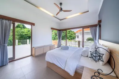 a bedroom with a bed and a large window at Villa Sunset-Near Seminyak Pool Free Airport Xfer in Seminyak