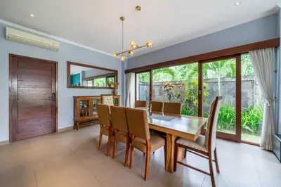 a dining room with a wooden table and chairs at Villa Sunset-Near Seminyak Pool Free Airport Xfer in Seminyak