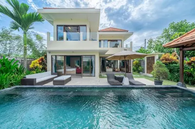 a villa with a swimming pool in front of a house at Villa Sunset-Near Seminyak Pool Free Airport Xfer in Seminyak