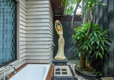 a bath tub with a statue of a woman on the side of a house at Bougenville 4 BR Villa Seminyak CYN in Seminyak