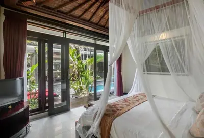 a bedroom with a bed with a mosquito net at Exquisite 3 BR Villa Seminyak CYN in Seminyak