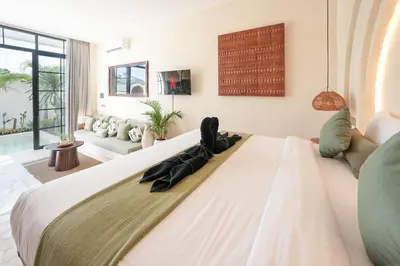 a bedroom with a large bed with black shoes on it at Villa Arya 1 in Kerobokan