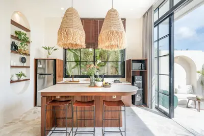 a kitchen with two chandeliers and a large island at Villa Arya 1 in Kerobokan
