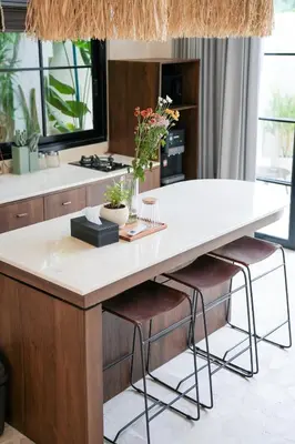 a kitchen with a large island with two bar stools at Villa Arya 2 in Kerobokan