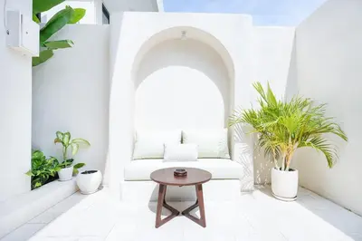 a living room with a white couch and potted plants at Villa Arya 2 in Kerobokan