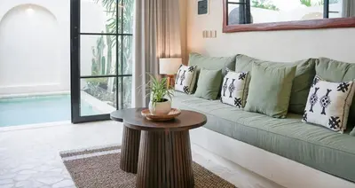 a living room with a green couch and a table at Villa Arya 2 in Kerobokan