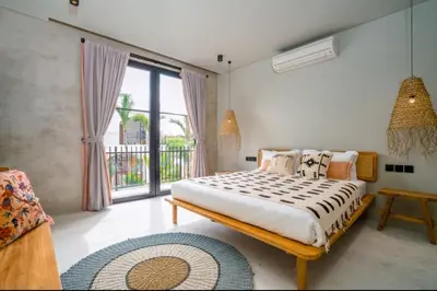 a bedroom with a bed and a large window at Villa Javel in Seminyak