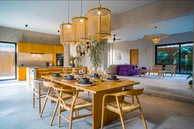 a kitchen and living room with a wooden table and chairs at Villa Javel in Seminyak
