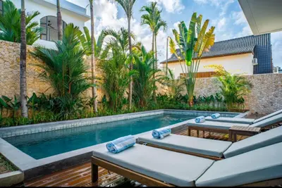 a pool with chaise lounge chairs and a swimming pool at Villa Javel in Seminyak
