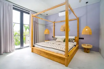 a bedroom with a wooden canopy bed in a room at Villa Javel in Seminyak