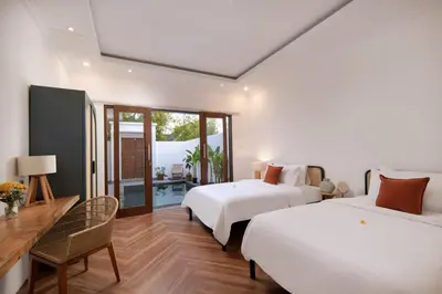 a bedroom with two beds and a table and chairs at Gorgeous 6 beds, 14 pax in the heart of Seminyak in Seminyak