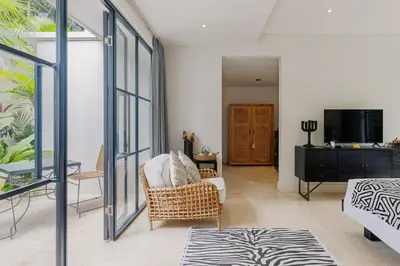 a living room with a chair and a tv at Sophisticated Luxe Martini 1 - 1BR Villa in Kerobokan