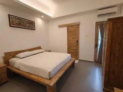 a bedroom with a bed and a wooden bed frame at Casa Walter in Seminyak