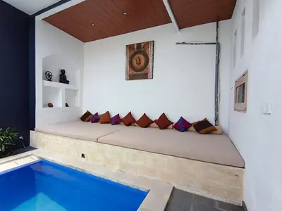 a bed in a room next to a swimming pool at Casa Walter in Seminyak