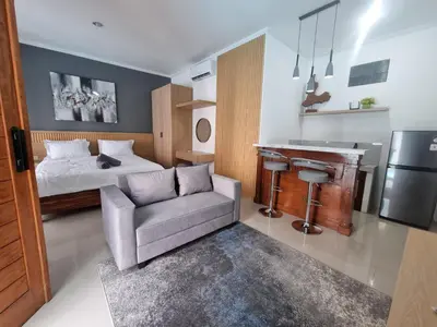 a bedroom with a bed and a couch and a desk at The Sania's in Seminyak