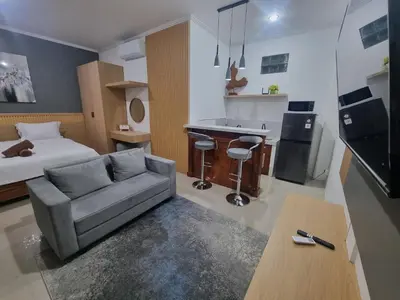 a living room with a couch and a bed at The Sania's in Seminyak