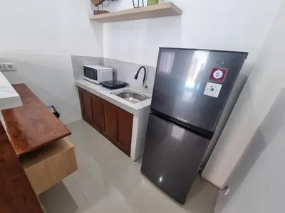 a kitchen with a stainless steel refrigerator and a sink at The Sania's in Seminyak