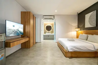 a bedroom with a bed and a flat screen tv at Forseti Athena Managed by ARM One Hundred in Seminyak