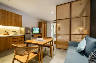 a living room with a table and a bedroom at Forseti Athena Managed by ARM One Hundred in Seminyak