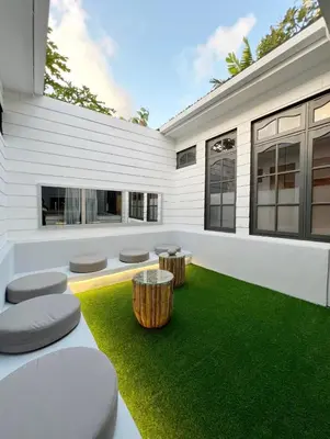 a house with a green yard with two stools at Cozy villa 777 near canggu 3BR in Kerobokan