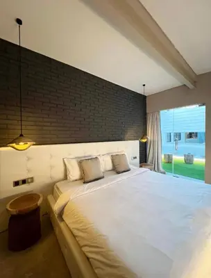 a bedroom with a large white bed with a window at Cozy villa 777 near canggu 3BR in Kerobokan