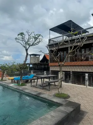 a pool with a picnic table next to a building at Brekele Berawa Beachhouse in Canggu