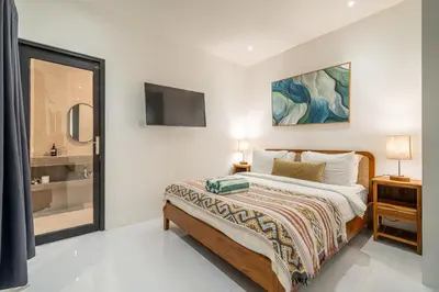 a bedroom with a bed and a tv on the wall at Nyma 2BR Villa Seminyak in Seminyak
