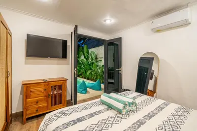 a bedroom with a bed and a flat screen tv at Nyma 2BR Villa Seminyak in Seminyak