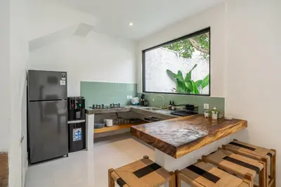 a kitchen with a large wooden table in a kitchen at Nyma 2BR Villa Seminyak in Seminyak