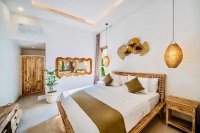 a bedroom with a large bed and a mirror at Villa Kensington in Seminyak