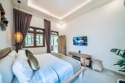 a bedroom with a bed and a window at Villa Kensington in Seminyak