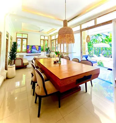 a dining room with a wooden table and chairs at Villa Kensington in Seminyak