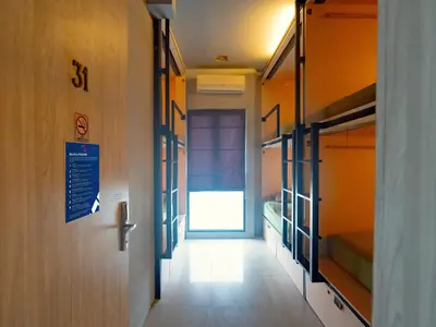 a hallway with bunk beds and a sign on a door at Kuta Cube Hostel in Kuta