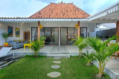 a villa with a garden and a house at Villa Mertanadi - Cosy 2bdrs in center Kerobokan - popular district in Seminyak