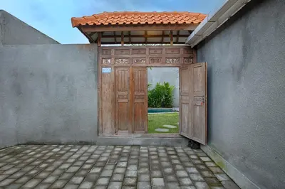 an open door to a building with a yard at Villa Mertanadi - Cosy 2bdrs in center Kerobokan - popular district in Seminyak
