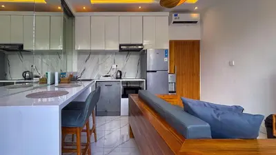 a large kitchen with a blue couch in the middle at Seminyak Loft 360 Private Pool Villas in Seminyak