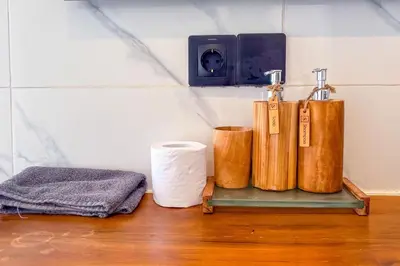 a shelf with three bottles and a towel at Seminyak Loft 360 Private Pool Villas in Seminyak