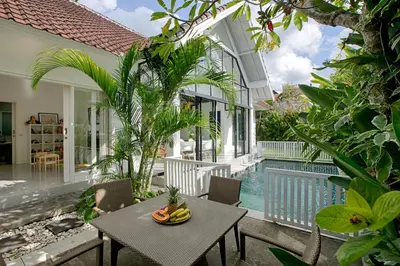 a patio with a table and chairs and a pool at Villa Pepita - Cosy 3bdrs villa, family friendly - Seminyak in Badung