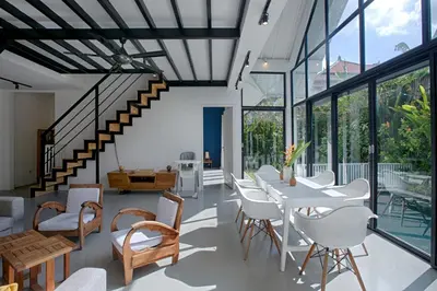a living room with a table and chairs and a staircase at Villa Pepita - Cosy 3bdrs villa, family friendly - Seminyak in Badung