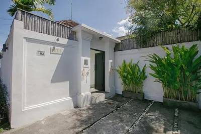 a white house with a door and a fence at Villa Pepita - Cosy 3bdrs villa, family friendly - Seminyak in Badung