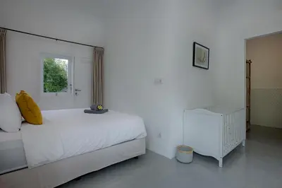 a white bedroom with a bed and a window at Villa Pepita - Cosy 3bdrs villa, family friendly - Seminyak in Badung