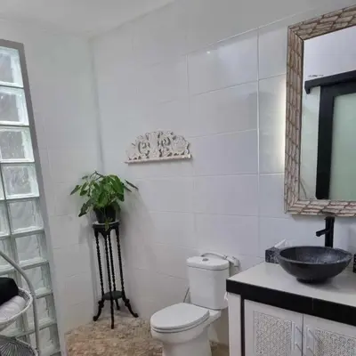 a bathroom with a toilet and a sink and a mirror at Villa Casa Jamika in Seminyak
