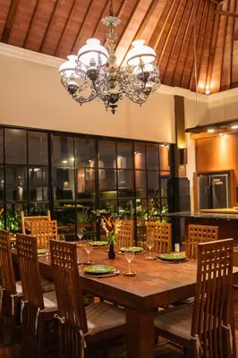 a dining room table with chairs and a chandelier at The Casa Amaya By Puri Asia in Jimbaran