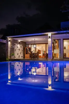 a house with a swimming pool at night at The Casa Amaya By Puri Asia in Jimbaran