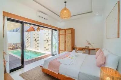 a bedroom with a bed and a swimming pool at Villa Tirtha at Nara Villa in Seminyak
