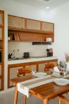 a kitchen with a wooden table and chairs at Villa Tirtha at Nara Villa in Seminyak