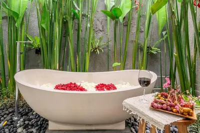 a bath tub sitting on a table with a glass of wine at Paradise in the Heart of Seminyak! in Seminyak