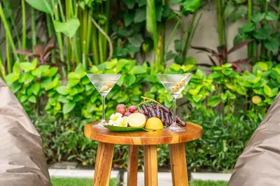 a table with a plate of fruit and two wine glasses at Paradise in the Heart of Seminyak! in Seminyak